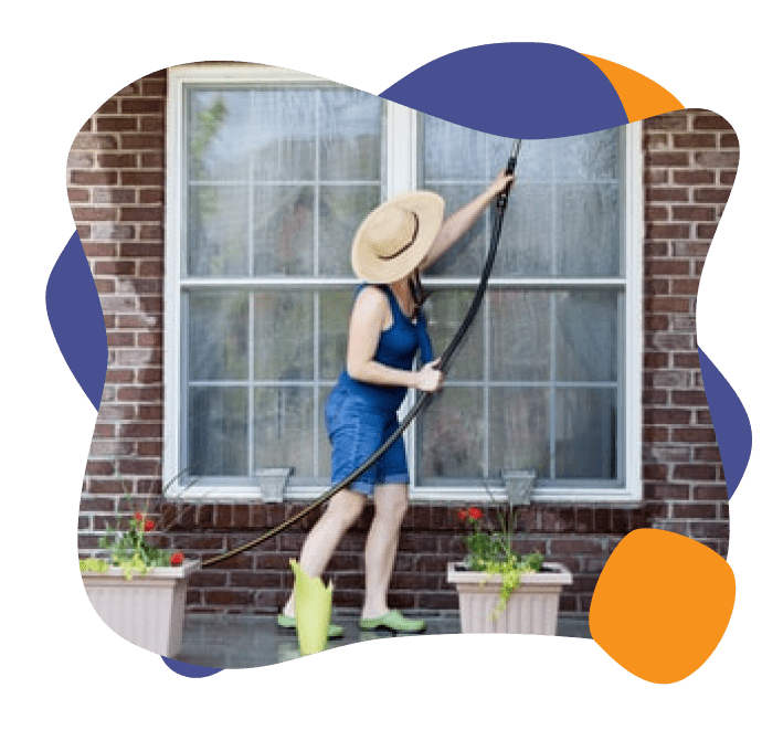 一位女士正在清洗她家的窗户. 